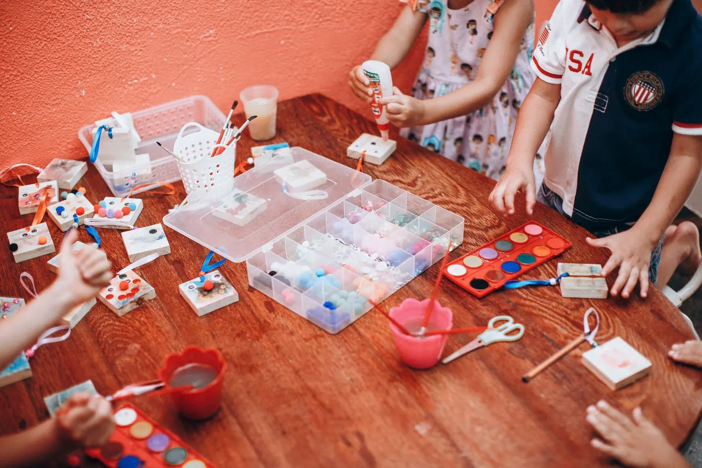 Children's hands busy with colourful craft materials